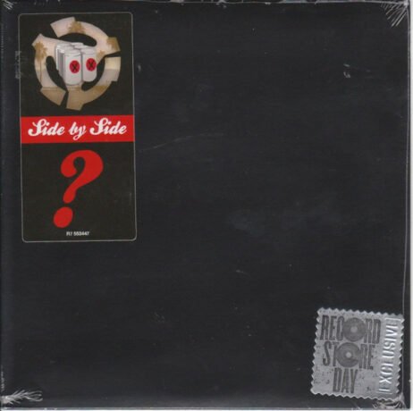 The image is of a vinyl record cover that seems to be part of a "Side by Side" series, likely released for Record Store Day, as indicated by the sticker in the bottom right corner. The cover has a black background with a prominent red question mark on the front, adding an element of mystery to the release. The "Side by Side" label suggests that the vinyl may contain two versions of a song by different artists. The circular logo at the top left features elements resembling broken records or tape, possibly signifying a reimagined or remastered classic.