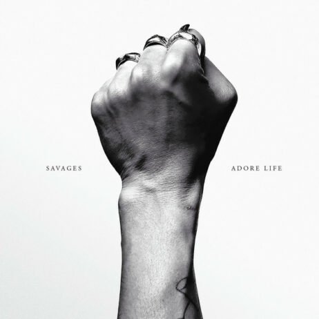 The image of the cover features a black-and-white photograph of a hand clenched into a fist, positioned against a stark white background. The band's name and the album title are printed in simple, uppercase fonts on either side of the fist.