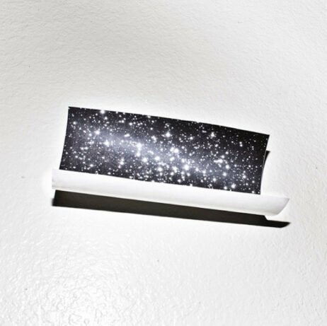 The image on the cover features a piece of paper partially rolled, with the image of a starry sky printed on it. The piece of paper casts a shadow onto the white background.