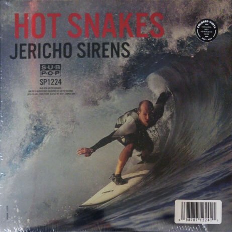 The image is the album cover for "Jericho Sirens" by Hot Snakes. It features a dynamic photograph of a surfer riding a powerful wave, giving the cover a sense of motion and intensity. The background is dominated by the swirling water. The album title "JERICHO SIRENS" and the band's name "HOT SNAKES" are displayed in bold uppercase letters at the top, with the band's name in red and the album title in black. The cover also includes the Sub Pop logo and catalog number.