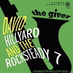 The image is of the album cover for David Hillyard and The Rocksteady 7 - The Giver. The design features a bold and abstract style, with a large, black silhouette of a saxophone set against a green background. The text is dynamic, with "David Hillyard and The Rocksteady 7" written in white and yellow, diagonally across the image. The title "The Giver" is placed at the top in a playful font. At the bottom, there's a note that reads, "Featuring Sean Wheeler on vocals."