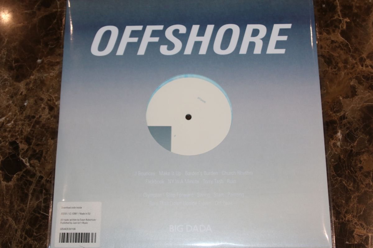 The image shows an album cover with a gradient background that transitions from dark blue at the top to light blue or white at the bottom. The word "OFFSHORE" is written in large, bold, white letters at the top of the cover. Below the title, there's a vinyl record visible through a circular cut-out in the cover. The list of tracks is written in small white text across the bottom half of the cover, and the logo for "BIG DADA" appears at the very bottom.