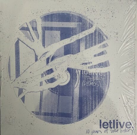 The image shows an album cover with a grunge, abstract design. At the center is a circular shape resembling a vinyl record, tinted in a faded blue tone. Across the record are thick, white, brush-like lines or abstract shapes that resemble tree branches or streaks of paint. Inside the circle, the words "letlive" and "10 years of fake history (DEMOS)" are written in a hand-drawn style. The background is white with speckles and a distressed texture. The album title "letlive 10 years of fake history" is placed in the bottom right corner in a clean, dark blue font.
