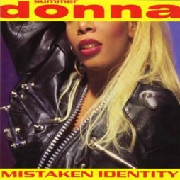 This image is the album cover for "Mistaken Identity" by Donna Summer. The design features a close-up photograph of Donna Summer, focusing on her lips and part of her face. She is wearing a bold black leather jacket adorned with metallic elements. Her blonde hair contrasts with the dark jacket, and the background is purple. At the top, her name, "Donna Summer," is written in large, bold red letters against a bright yellow background. The album title, "Mistaken Identity," is written in the same bold red font at the bottom of the cover.