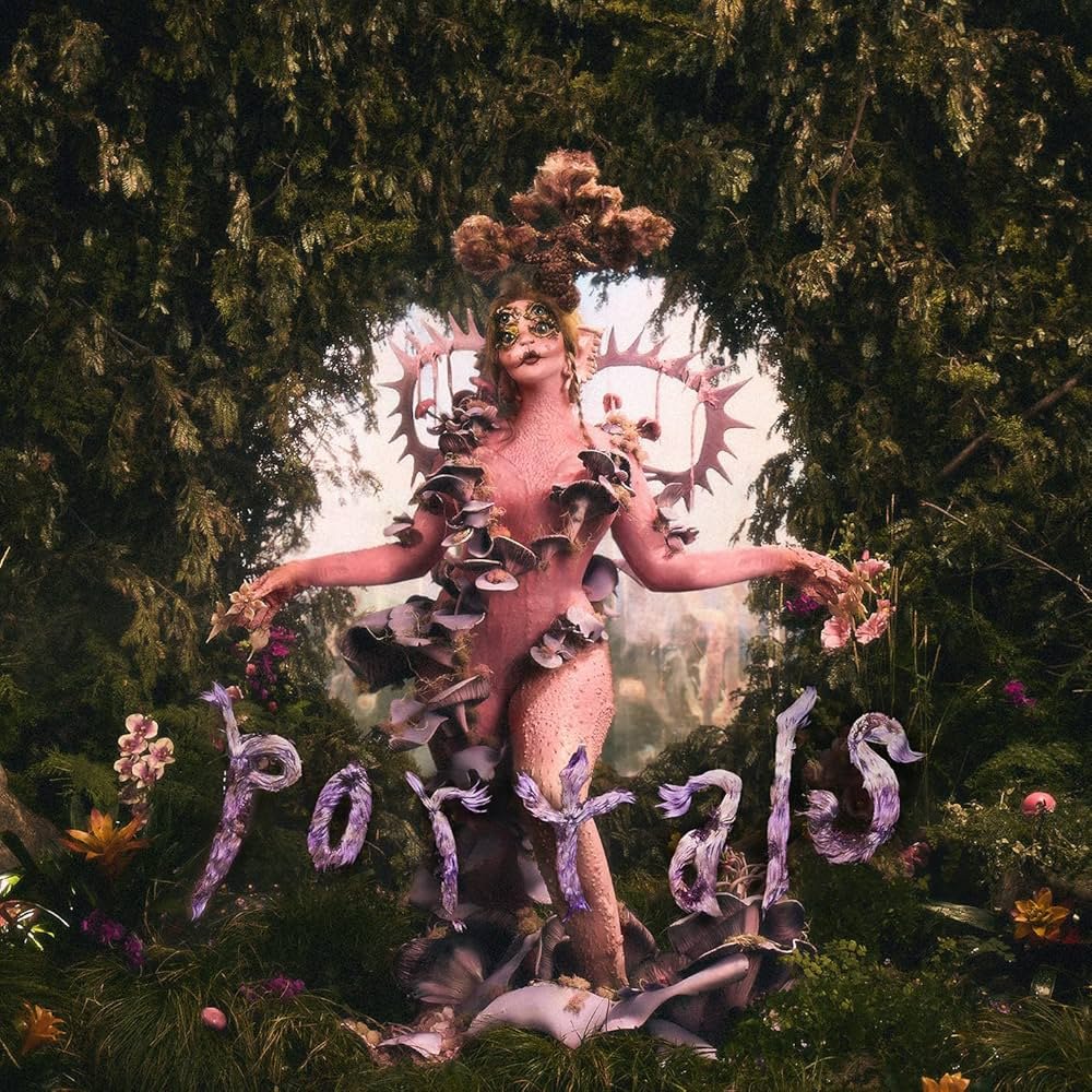 The album cover for "Portals" features an ethereal figure in a fantasy-like setting, surrounded by lush greenery. The character has a unique, otherworldly appearance, adorned with natural elements like flowers and fungi growing from their body. The word "Portals" is spelled out at the bottom in a flowing, organic font that resembles tree branches or vines. The overall theme evokes a sense of magic, nature, and transformation, creating a surreal, mystical atmosphere.