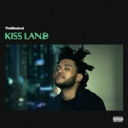 This is the album cover for The Weeknd - Kiss Land (2LP). It features a man looking at the camera in the centre with a blurred background of green, blue and black.