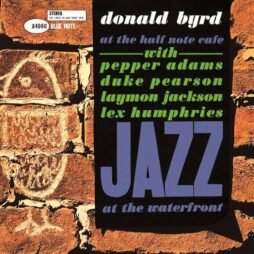 This is the album cover for Donald Byrd - At The Half Note Cafe Volume 1. It features a brick background with cave like drawings with the album name and features highlighted.