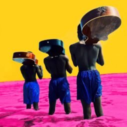The album cover for Common - A Beautiful Revolution Pt 2 features three figures, dressed in blue shorts, seen from the back, carrying guitars on their heads as they walk through a bright pink landscape. The background is a vivid yellow, creating a striking contrast with the pink and blue.