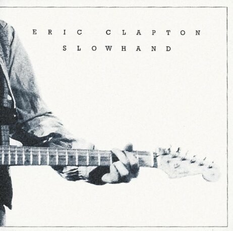 The cover of Eric Clapton's - Slowhand album features a minimalist, sepia-toned image of Clapton's right hand on a guitar neck. The album title and artist's name are displayed in a simple, uppercase font above the image. The focus on Clapton's hand captures his nickname, "Slowhand".