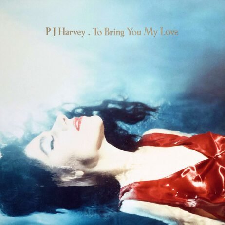 A woman with pale skin and dark hair floats serenely in water, eyes closed and lips painted a vibrant red. She is wearing a red dress that contrasts with the blue water around her. The image exudes a sense of calm and ethereal beauty. The text "P J Harvey . To Bring You My Love" is positioned above her head in a simple, elegant font.