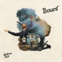 The album cover features a collage of various images. In the center, Anderson .Paak is depicted singing passionately into a microphone, surrounded by clouds of smoke. Other smaller scenes include a person standing by a car, people crossing their arms, and a person holding their head in a stressed pose. The artwork has a surreal, dream-like quality with vibrant colors contrasting against a plain background. The title "Oxnard" is displayed in a bold, stylized font in the top right corner.