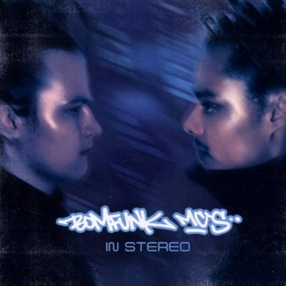 This is the album cover for Bomfunk MC's - In Stereo (2LP) (Translucent Red & Blue Marbled Vinyl). It fatures an image of two men blurred in a blue haze looking at each other.