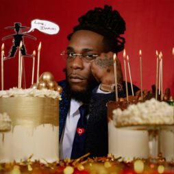 This is the album cover for Burna Boy - Love, Damini (2LP). It features a man with his fist on his chin in the centre with two birthday cakes either side.